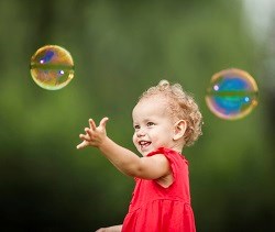 Baby spielt mit Seifenblasen