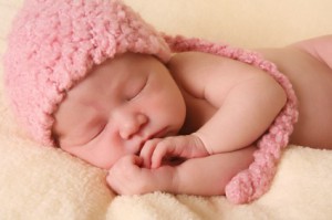 Baby mit rosa Wollmütze schläft